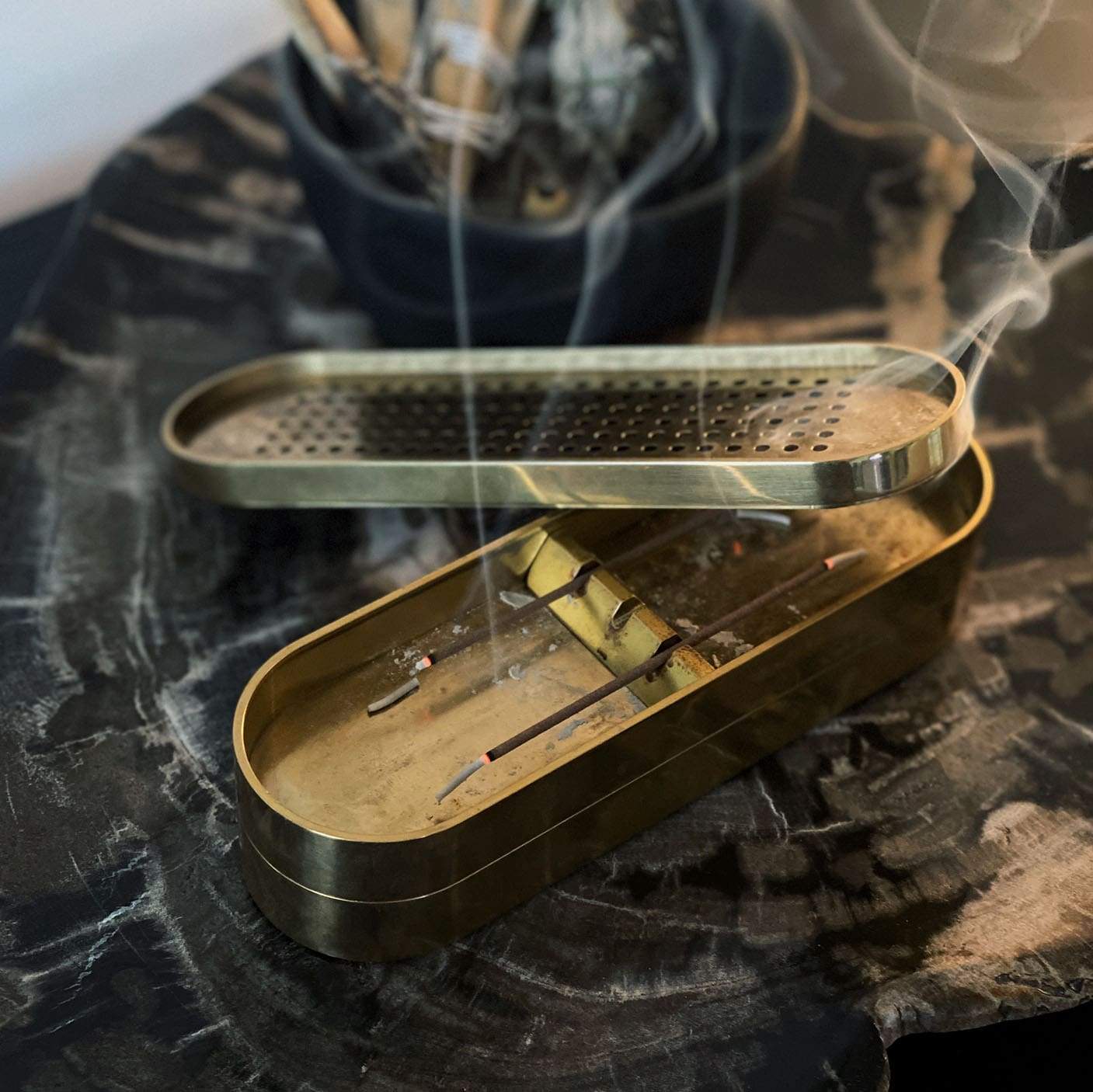 brass incense burner on petrified wood stone tray