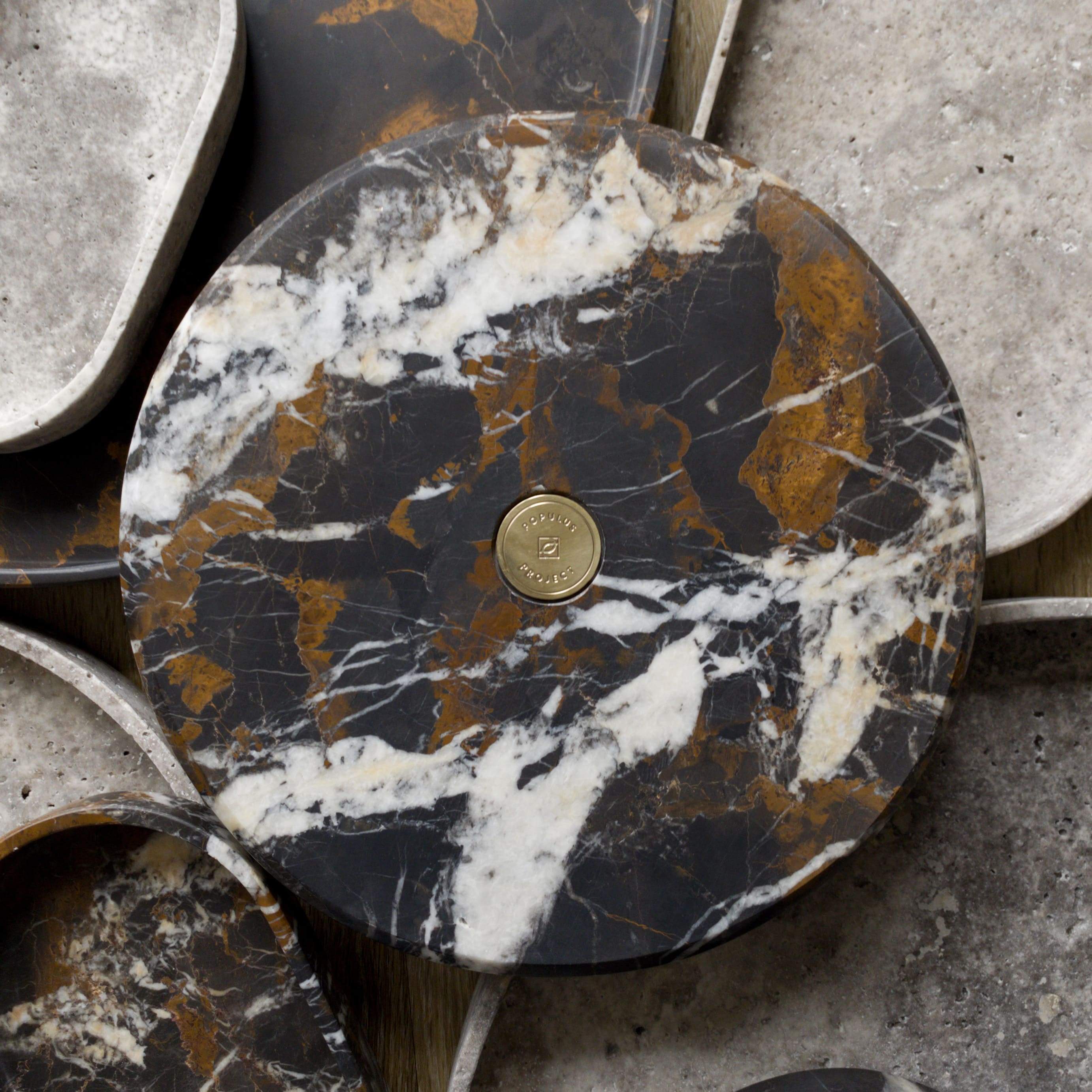 marble and travertine stone round trays with brass logo coin used as home decor and accessories